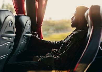 Man leaning back in seat on charter bus